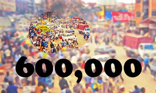 A sandy Ugandan street with people and traffic. 600,000 is overlaid in white text
