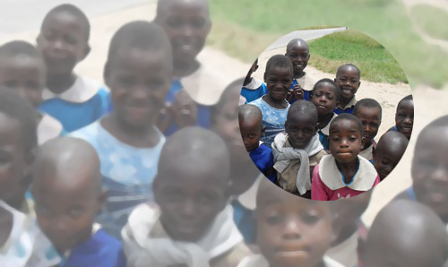 African children gathered on the grass smiling for the camera