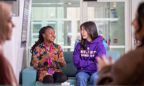 Two students on a sofa in discussion