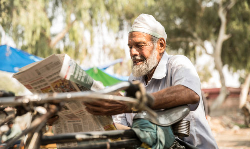 Man sat down reading a newspaper in India