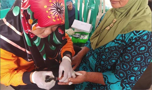 Nurse testing for diabetes with a finger prick test.