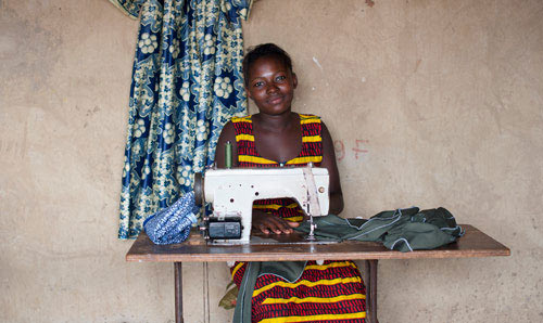 Smiling young woman with a sewing machine